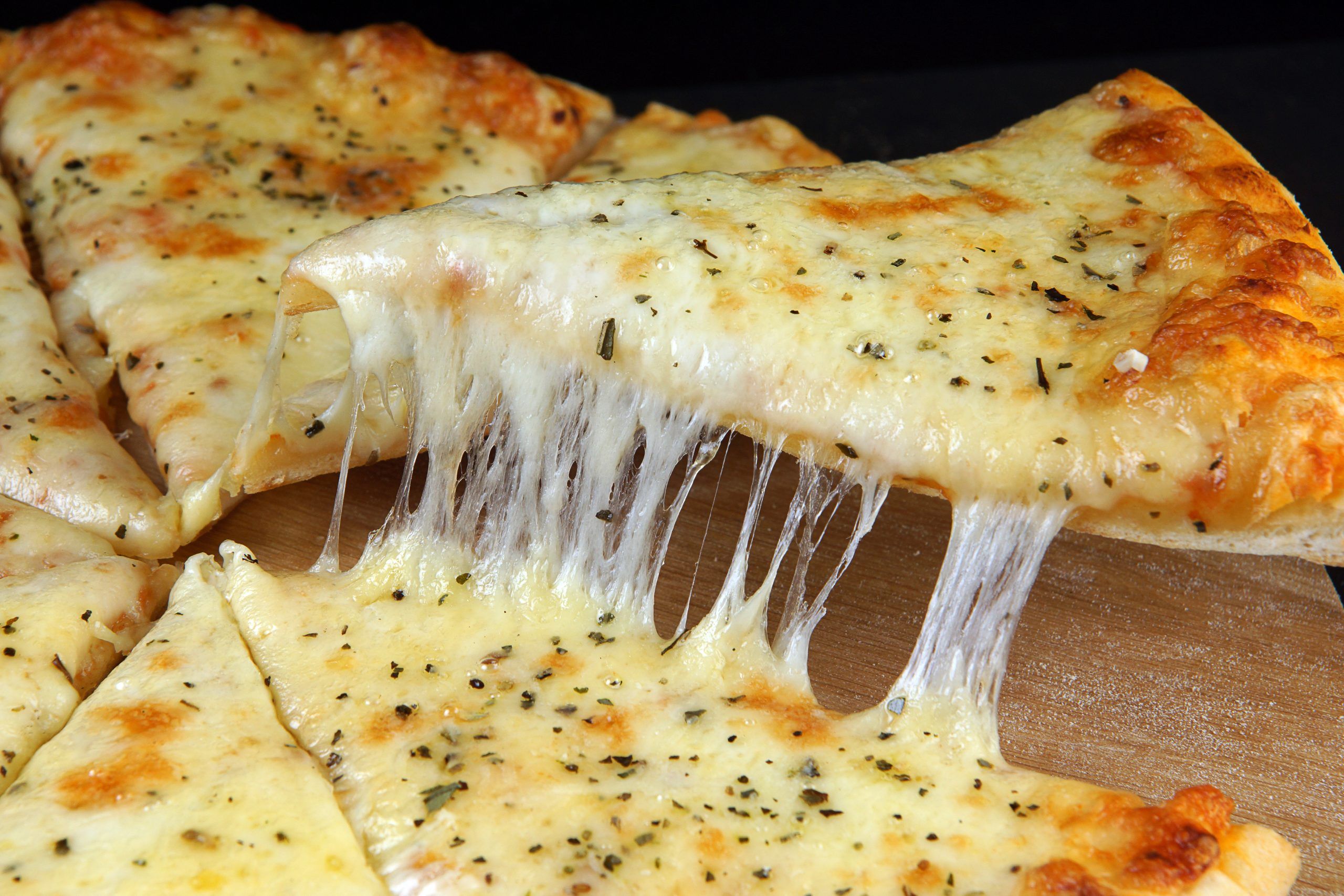 appetizing cheese pizza cut into pieces scaled - جبنة شبيه الموزاريلا البديل المثالي لمحبّي الأجبان