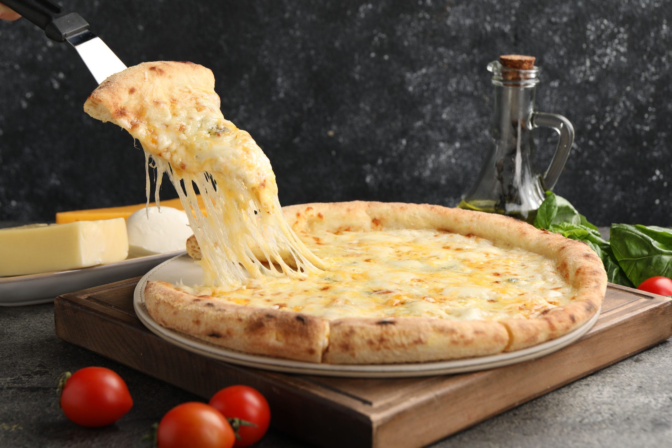 taking piece delicious cheese pizza grey table scaled - جبنة شبيه الموزاريلا البديل المثالي لمحبّي الأجبان