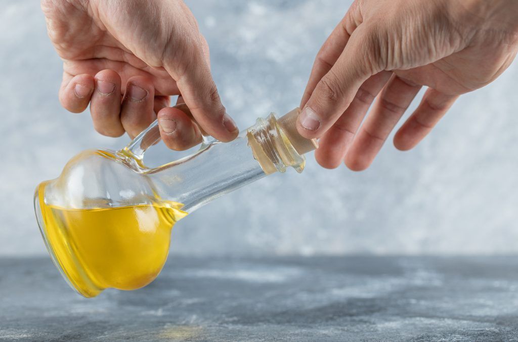 man trying openi bottle oil high quality photo - أفضل زيت للطبخ خالي من الكوليسترول الخيار الصحي لمطبخك